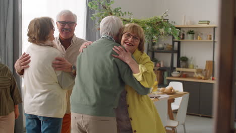 cheerful senior couple greeting friends at home