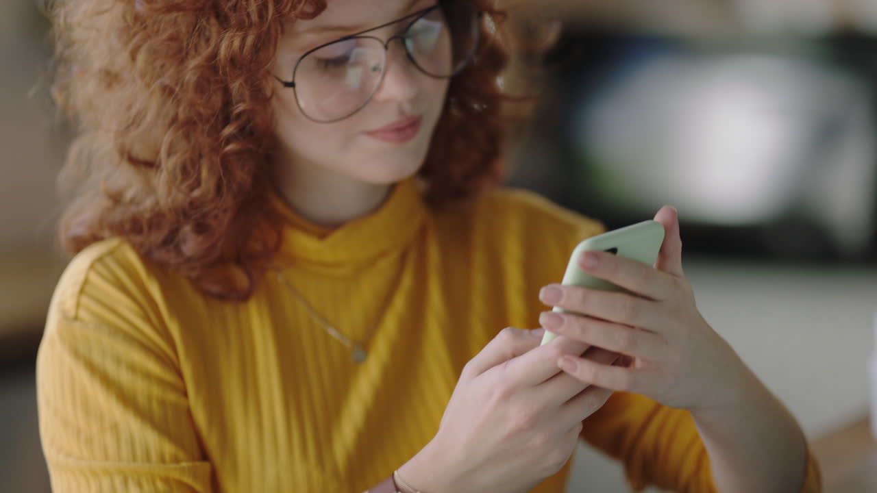 ritratto di una giovane rossa con lo smartphone che scatta una foto a un food blogger in un caffè che si diverte a condividere lo stile di vita sui social media indossando occhiali