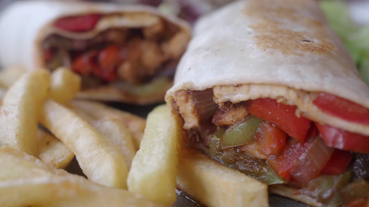 Primer plano de wraps de fajita de pollo servidos con patatas fritas doradas