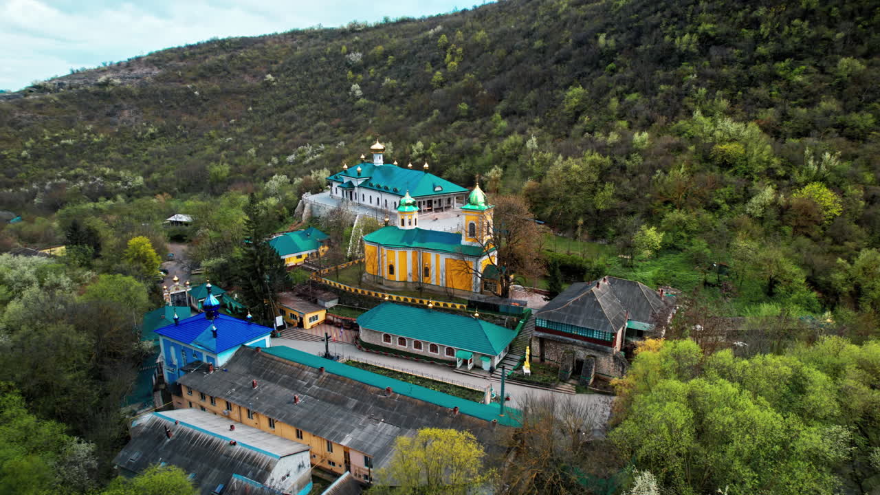 Aerial drone view of Saharna Monastery, Moldova. Monastery with churches located in a valley covered with lush forest