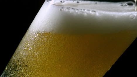 cerveza vertiendo en un vaso sobre un fondo negro