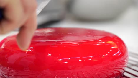 sweet strawberry sauce pouring over delicious cream cake in gourmet delicatessen close up