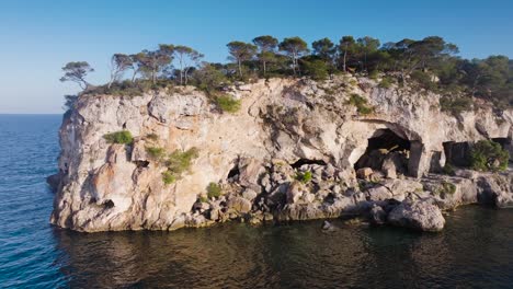 aerial - coastal limestone cliff with historic cave system, mallorca