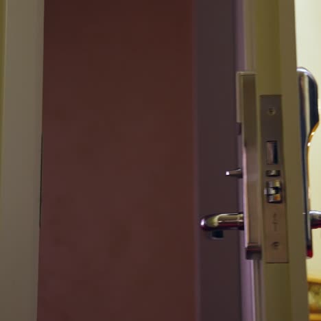 unrecognizible man arrived to hotel and opens the room with electronic key. selective focus on a door handle