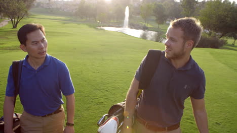 slow motion shot of male golfers walking along fairway