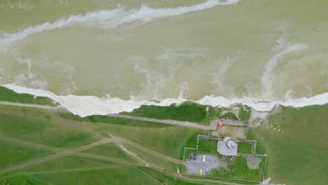 Top-down-view-of-Belle-Tout-Lighthouse,-white-cliffs-and-sea-taken-by-dji-mini-3-pro-drone-in-Eastbourne-England