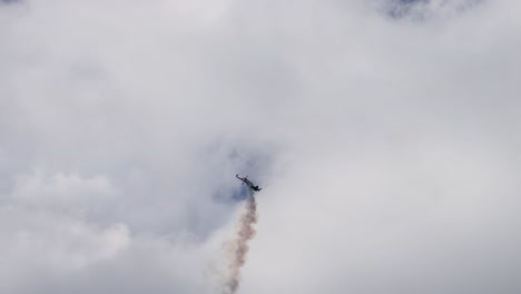 el avión ejecuta maniobras con rastro de humo contra las nubes