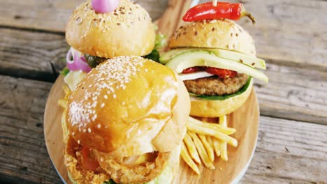 hamburgers and french fries on wooden board