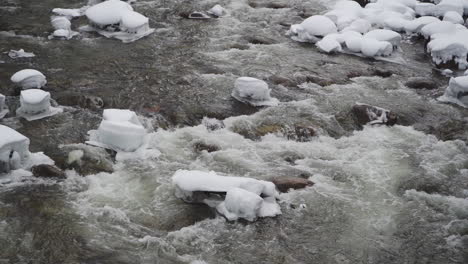 Slow-Motion,-Freezing-Stream-Cascading-Through-Snow-Covered-Ice-and-Rocks-in-Yosemite-During-Winter