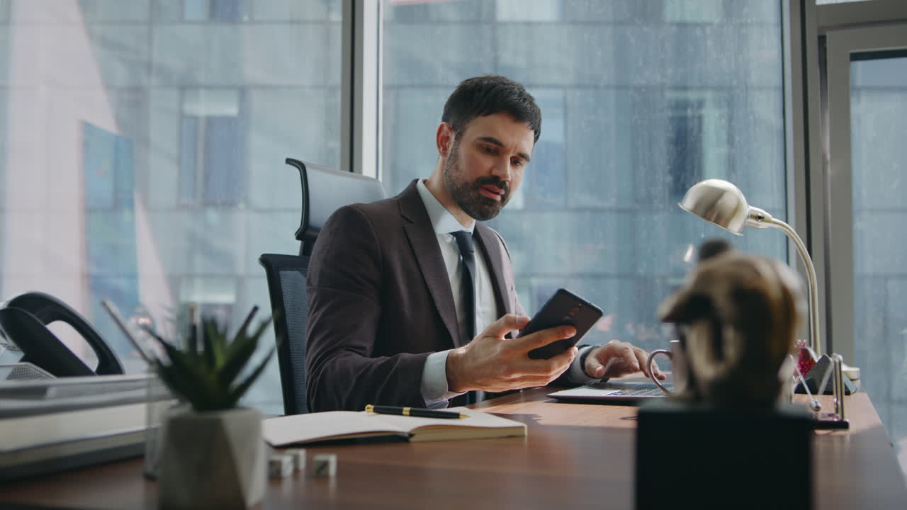 lavoratore aziendale che risponde a una chiamata telefonica che lavora al computer portatile in primo piano. uomo che parla