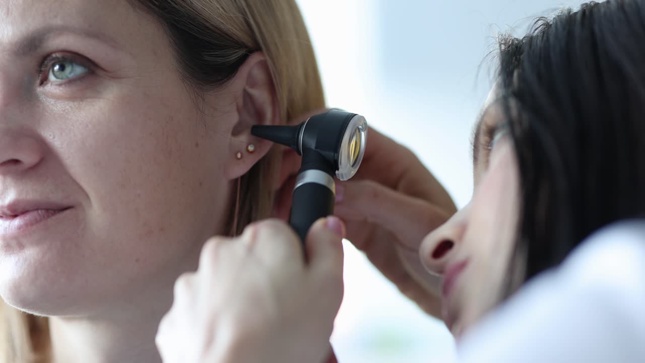 Diagnosi ORL ed esame dell'orecchio con otoscopio di una donna