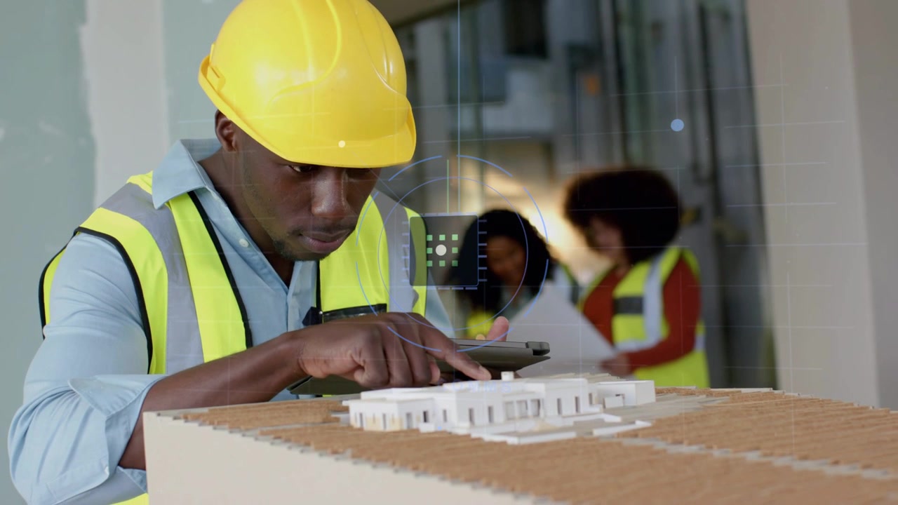 Tablet alert appearing, supervisor checking tablet, pointing at model, verifying plans with team