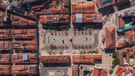 overhead aerial hyperlapse of people on large public square surrounded by residential houses in lisbon, portugal