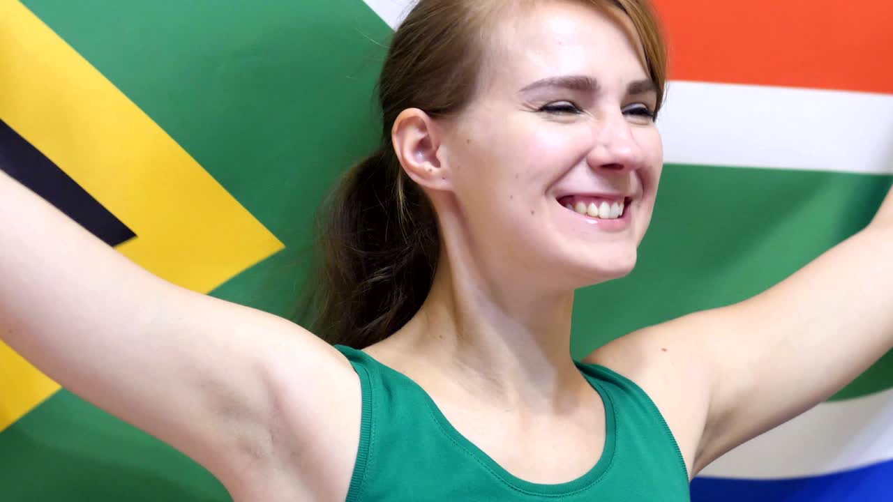 남아프리카 공화국의 젊은 여성이 느린 동작으로 남아프리카공화국의 발을 들고 축하합니다.