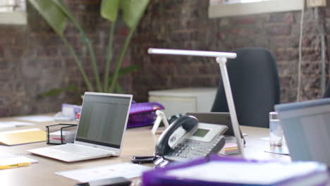 Empty-office-with-technology-devices-with-chart-on-screen-and-documents-on-table-in-slow-motion