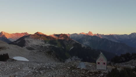 bellas imágenes aéreas de la puesta de sol en el monte brew que muestran montañas y una cabaña de madera solitaria en columbia británica canadá 4k