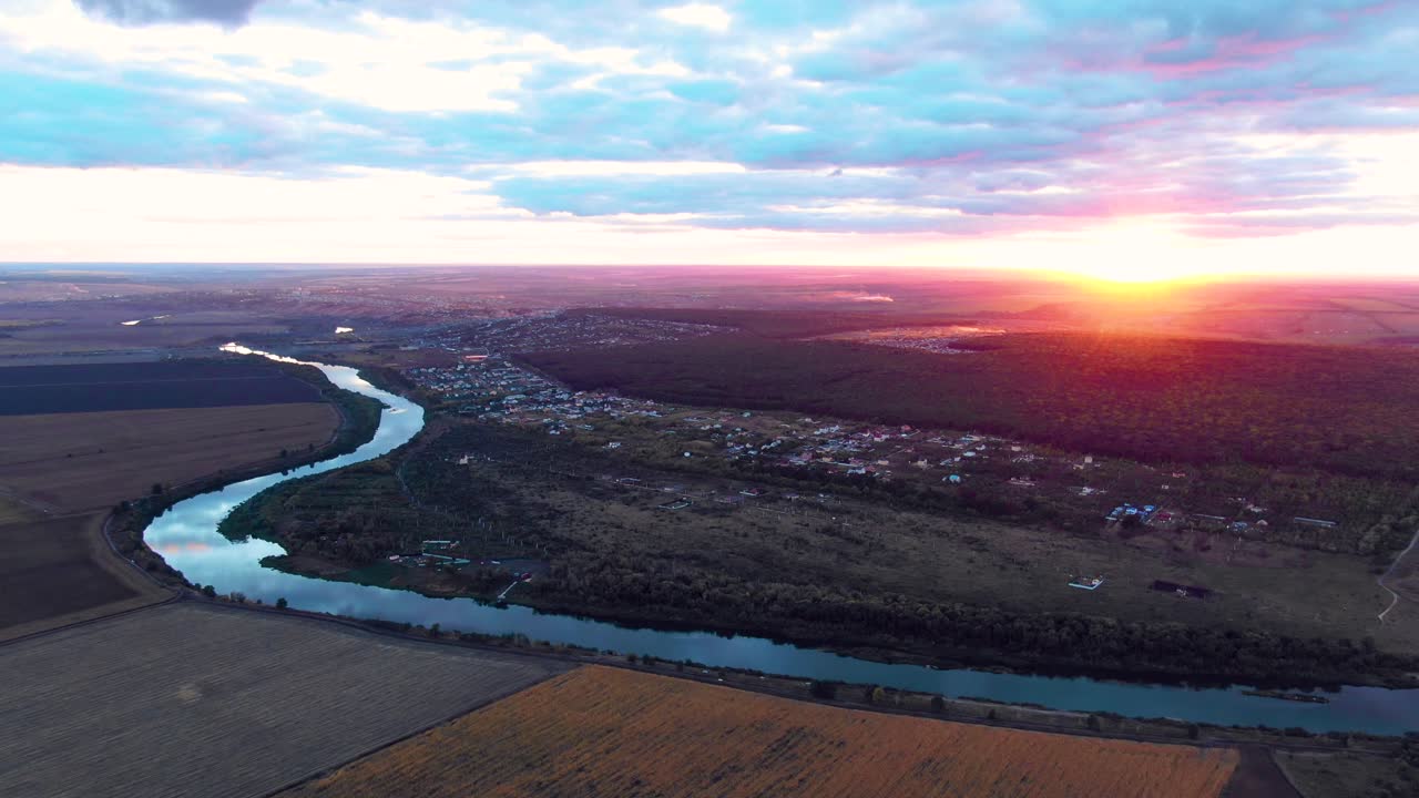puesta de sol sobre un río sinuoso y el pueblo desde arriba