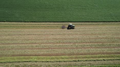 En-Un-Campo-Agrícola-En-El-Suroeste-De-Wisconsin,-Un-Agricultor-Rastrilla-El-Heno-Con-Un-Rastrillo-Giratorio-Para-Heno-7