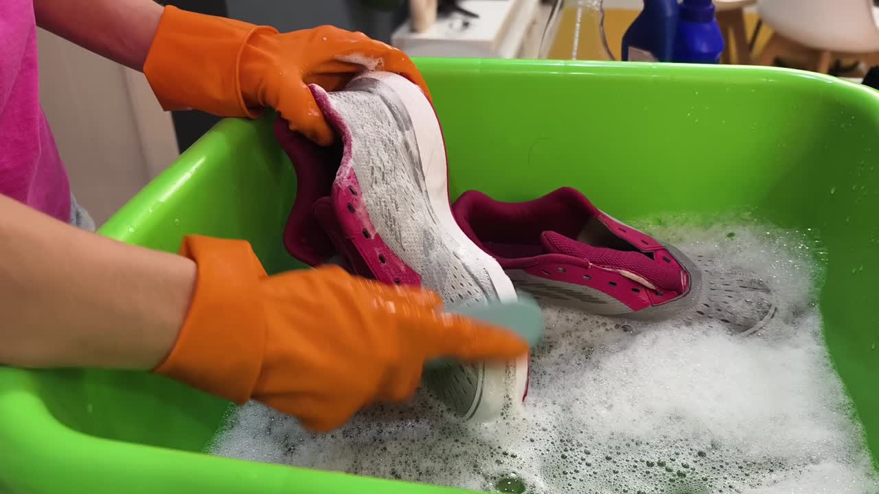 Cleaning shoes in a basin with soap and water