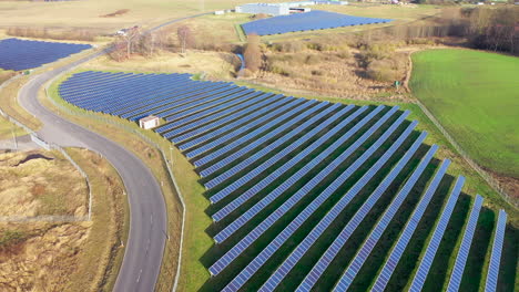 eine drohne fliegt über eine riesige photovoltaik-freiflächenanlage, die aus vielen solarmodulen besteht