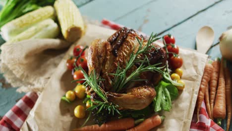 close up view of cooked chicken and multiple food ingredients on wooden surface