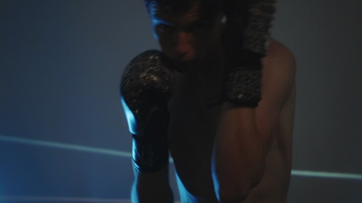 Boxeador entrenando y practicando golpes en un gimnasio - primer plano