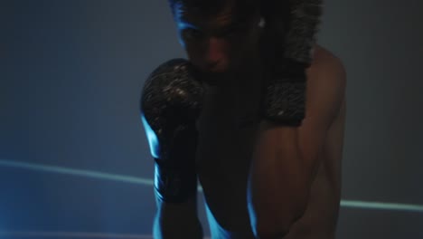 boxer training and moving punching in a gym - close up