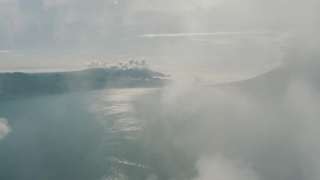 Vista-Aérea-De-Drones-Volando-A-Través-De-Las-Nubes-Revelando-El-Hermoso-Lago-De-Atitlán,-Guatemala