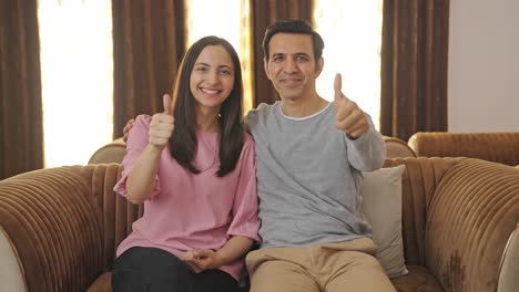 happy indian couple showing thumbs up symbol
