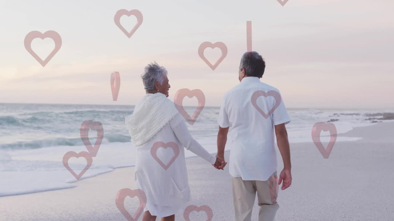 Walking on beach, elderly couple holding hands with heart animation overlay