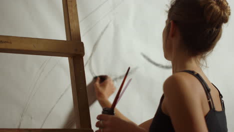 mujer talentosa trabajando en un estudio de arte. pintora dibujando en un lugar de trabajo de arte.