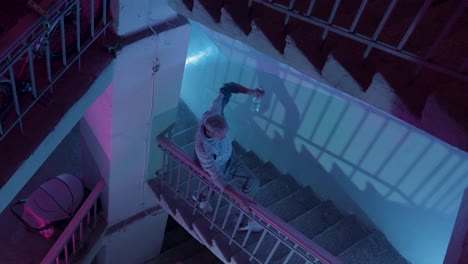 man walking down spiral staircase at night