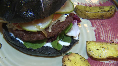 black bun vegan burger with fries