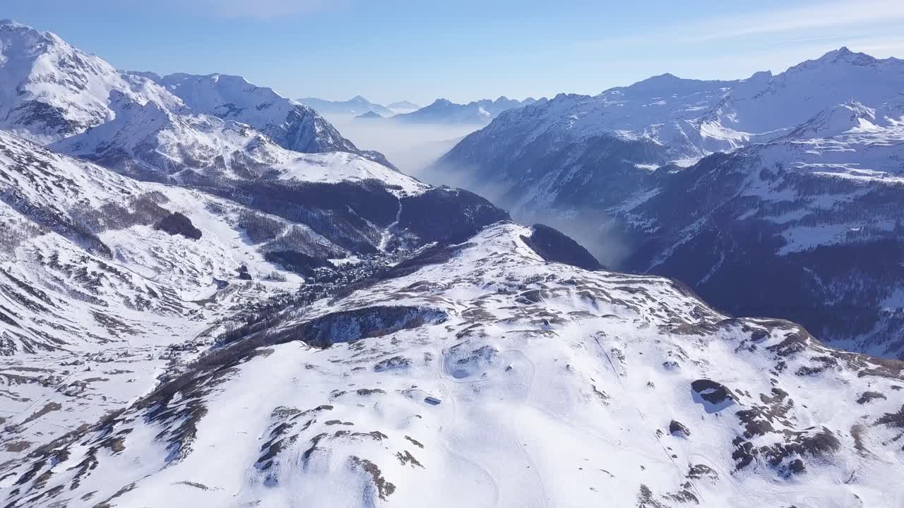 Rivelazione con drone delle Alpi italiane in inverno, molta neve, valle sullo sfondo, panoramica verso l'alto.