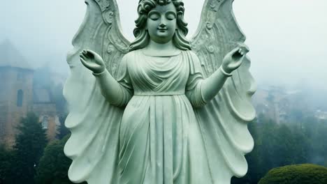 estatua de piedra de un ángel con las alas extendidas da la bienvenida a los visitantes a un cementerio neblínico, evocando sentimientos de paz y recuerdo