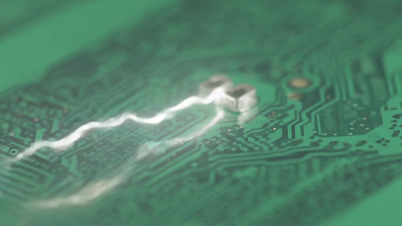 Appearing faint arc following copper trace toward SMD on green PCB, causing bright halo, copy space
