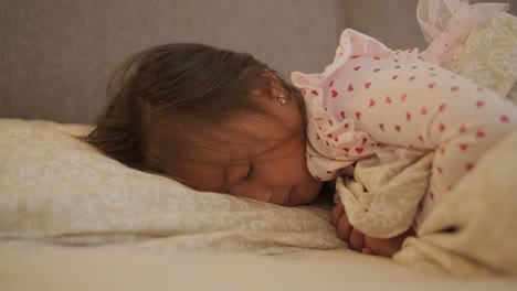 una niña durmiendo tranquilamente en la cama