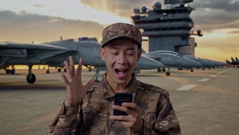 excited soldier on aircraft carrier using smartphone