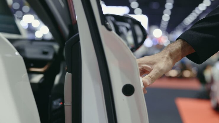 Person opening a car door at a car showroom