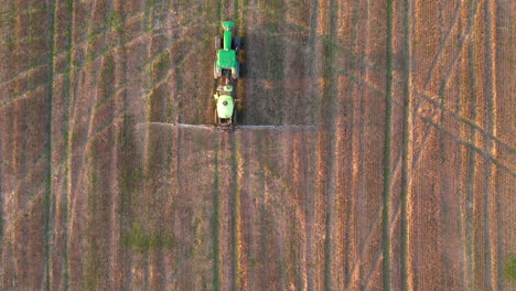 vista aérea de un tractor rociando plaguicidas en el campo