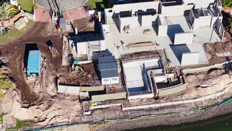 aerial footage captures construction progress on a residential site in gold coast, australia, highlighting machinery and workers in action