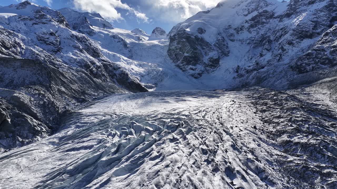Engadin Switzerland glacier and alpine peaks, drone pullback view over majestic snowy mountains and ice textures