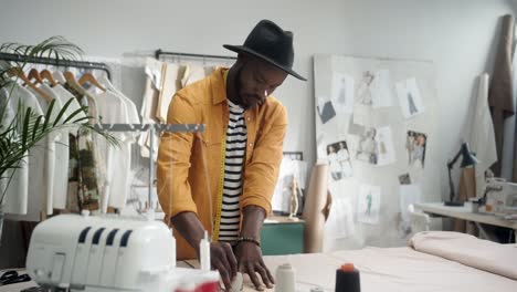 cheerful young designer drawing an outline on the cloth in studio