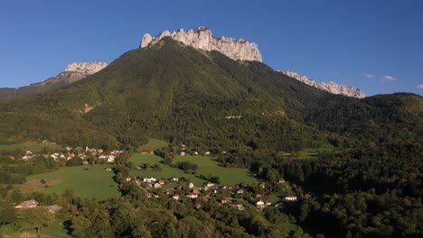 pequeño pueblo debajo de una montaña en los alpes franceses