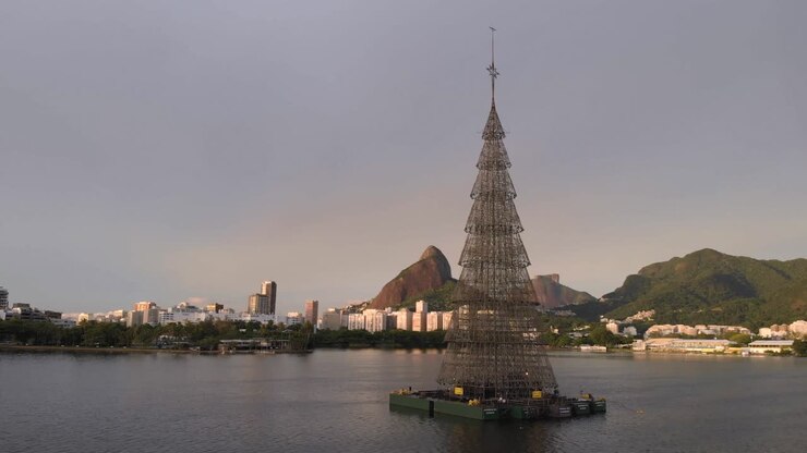 Panorering omkring verdens højeste flydende juletræ fra 2018, beliggende i Rio de Janeiros bysø, med byens vartegn Two Brothers-toppen og Gavea-klippen i baggrunden.