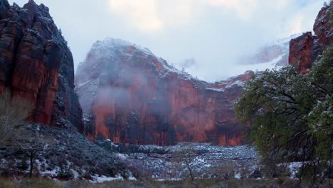 Reveal-shot-of-the-gorgeous-mountains-of-Zion-National-Park-during-the-winter-as-the-snow-falls