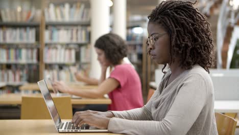 serious african american student working with laptop