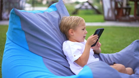 child playing with smartphone in garden