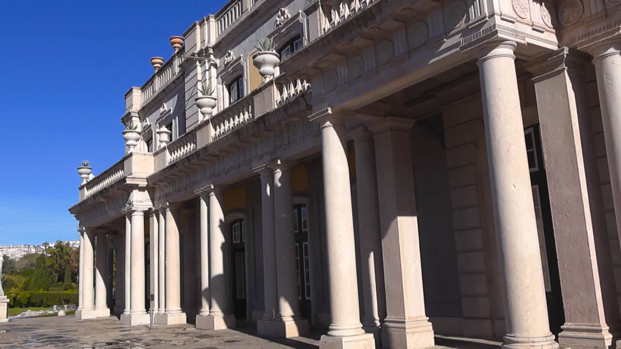 Elegante colonnato e facciata in pietra ornata del Palazzo Nazionale di Queluz sotto un cielo azzurro e limpido in Portogallo
