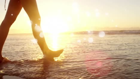 -Woman-walking-barefoot-in-ocean-on-the-sand-against-sunshine-on-ocean